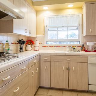 A bright and tidy kitchen with wooden cabinets and modern appliances.