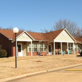 A suburban residential building with porches under a clear blue sky.