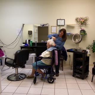 A hairstylist working on a client's hair in a salon setting.