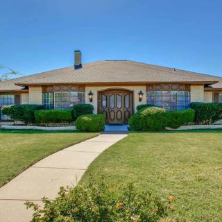 A suburban house with a well-maintained lawn and a clear blue sky.
