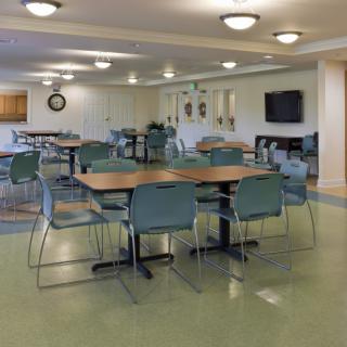 An empty dining area with tables and chairs, well-lit and spacious.