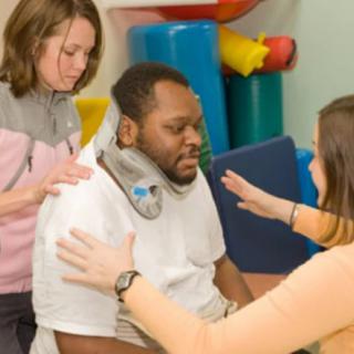 Therapists assisting a patient during a physical therapy session.