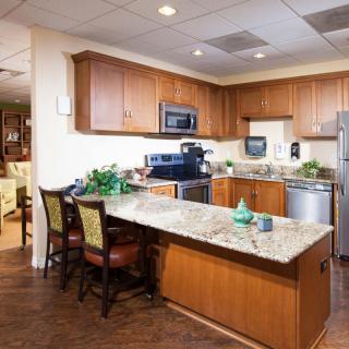 A modern kitchen with wooden cabinets, granite countertops, and stainless steel appliances.