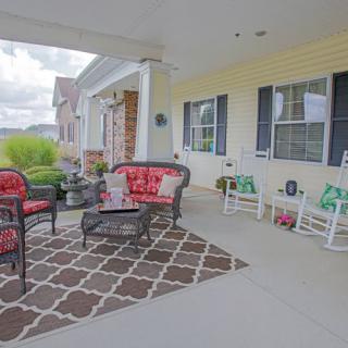 A cozy front porch with comfortable seating and colorful cushions.