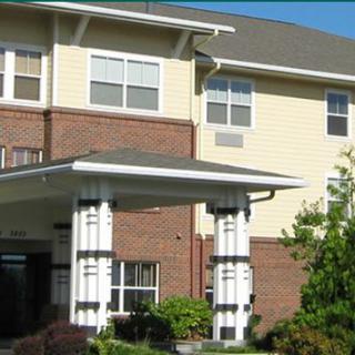 A view of a residential building entrance with brick and siding exterior.