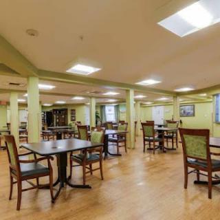 A spacious and inviting dining area with wooden tables and chairs, featuring ample lighting.