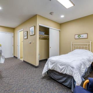 A cozy bedroom with a single bed and simple decor.