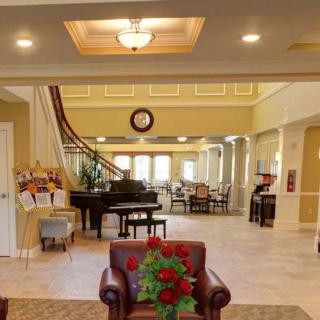 A bright and spacious lobby featuring a grand piano, comfortable seating, and elegant decor.