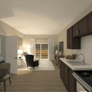 A modern open-plan kitchen and living area with stylish furnishings and soft lighting.