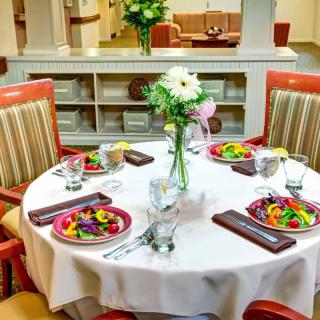 A beautifully set dining table with salads and a floral centerpiece in a restaurant setting.