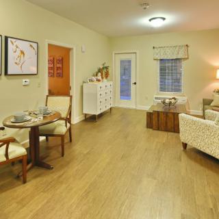 A cozy living room with a dining area, featuring stylish furniture and warm lighting.