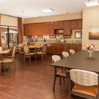 A spacious kitchen and dining area with wooden cabinets and tables.