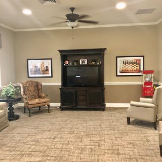 A cozy living room with a television, seating area, and decorative artwork on the walls.