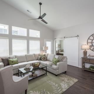 A modern living room with a comfortable sectional sofa, coffee table, and ample natural light streaming through large windows.