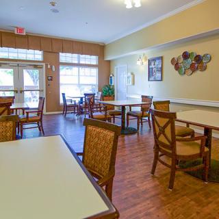 A cozy dining area with wooden floors and tables set for guests.