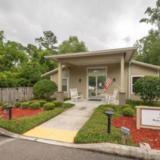 A small house with a landscaped front yard, featuring a garden and pathway leading to the entrance.