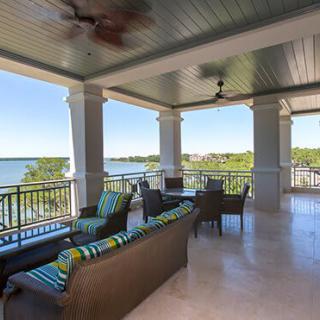 A spacious balcony with comfortable seating overlooking a picturesque lake.