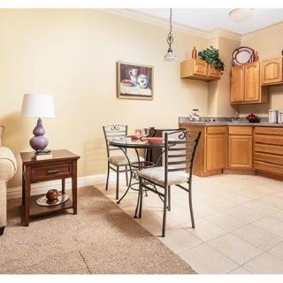 A cozy kitchen with a dining area featuring wooden cabinets and a small table for two.