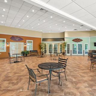 A spacious community center dining area with multiple tables and chairs arranged for social gatherings.