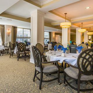 A beautifully set dining area with elegant lighting and neatly arranged tables and chairs.