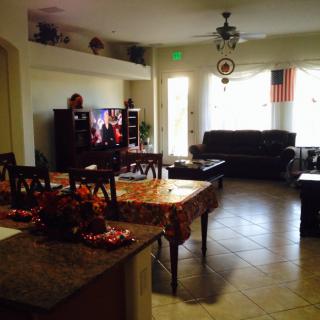A cozy living and dining area featuring a kitchen island, comfortable sofa, and a television.