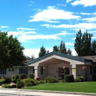A well-maintained residential building under a bright blue sky with scattered clouds.