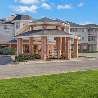 A modern residential building with a covered entrance and well-maintained landscaping.