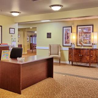 A well-lit reception area with a desk and stylish furnishings.