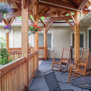 A cozy porch featuring rocking chairs and a wooden frame, perfect for enjoying the outdoors.