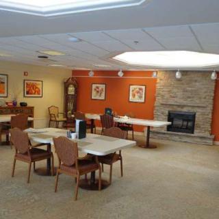 A cozy community lounge featuring a fireplace and comfortable seating, designed for relaxation and social gatherings.
