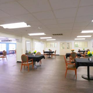 A spacious dining area featuring tables and chairs, designed for comfortable gatherings.