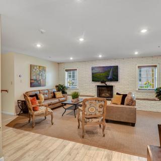 A cozy living room featuring comfortable seating, a fireplace, and a mounted television.