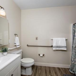 A modern bathroom with a toilet, sink, and a shower area featuring a patterned curtain.