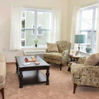 A cozy living room with patterned armchairs, a sofa, and a central coffee table.