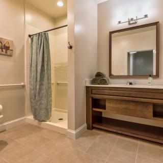 A modern bathroom with a shower, vanity sink, and mirror.