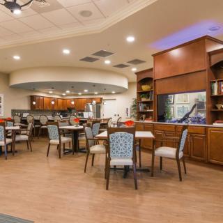 A cozy restaurant dining area with neatly arranged tables and chairs, warm lighting, and a welcoming atmosphere.