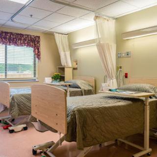 A hospital patient room with two beds, equipped for healthcare needs.
