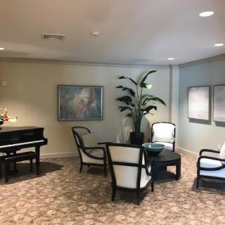 A cozy lobby area with elegant seating, a piano, and decorative artwork.