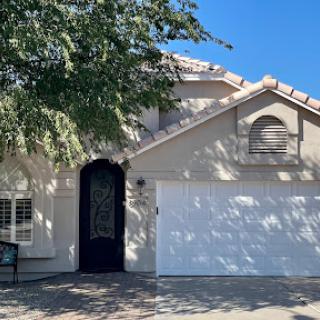 A charming residential house featuring a garage and a welcoming front entrance.