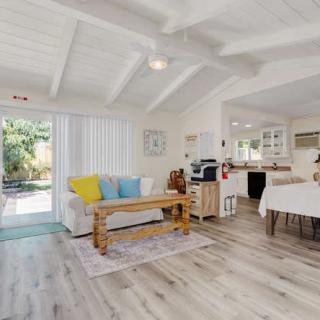 A bright and airy open-plan living room with modern furnishings, including a cozy sofa, wooden coffee table, and adjacent dining area.