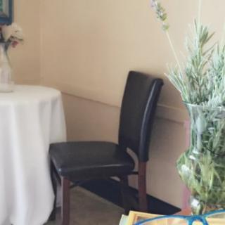A cozy corner with a table, chair, and decorative plants.