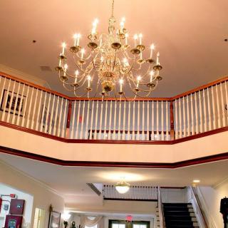 Elegant lobby featuring a grand chandelier and staircase.