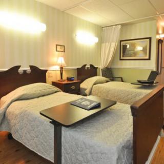 A cozy hotel room with twin beds, adorned with elegant decor and soft lighting.