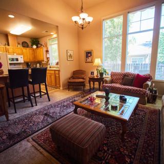 A cozy living room with an open kitchen and warm lighting.