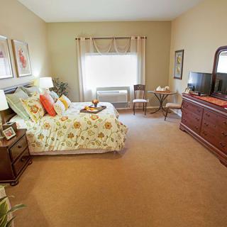 A cozy bedroom with floral bedding and classic wooden furniture.