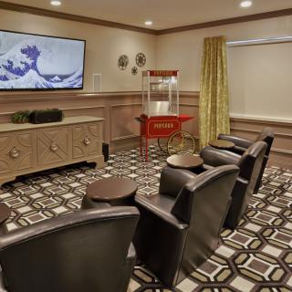 A cozy home theater room with comfortable seating, a large television, and a popcorn machine.