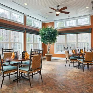 A bright and inviting dining area featuring modern furniture and large windows for natural light.