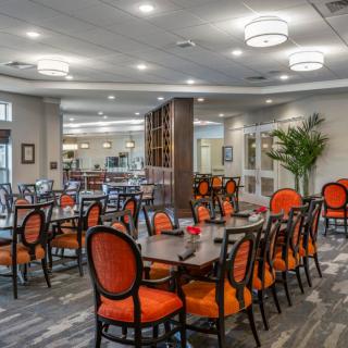 A modern dining area featuring orange chairs and contemporary decor.