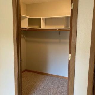 Empty walk-in closet with built-in shelves and storage space.