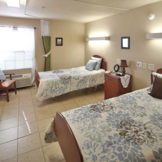 A cozy bedroom with twin beds and soft lighting.
